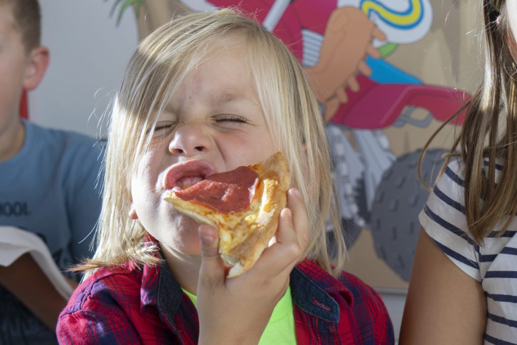 Kind beißt in Pizza
