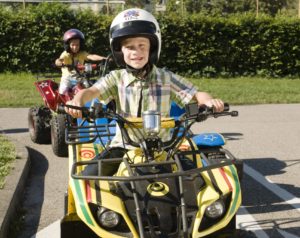 Kind auf Quad mit Helm