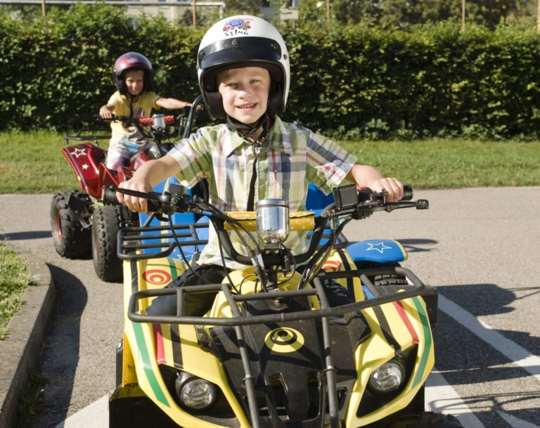 Kind auf Quad mit Helm